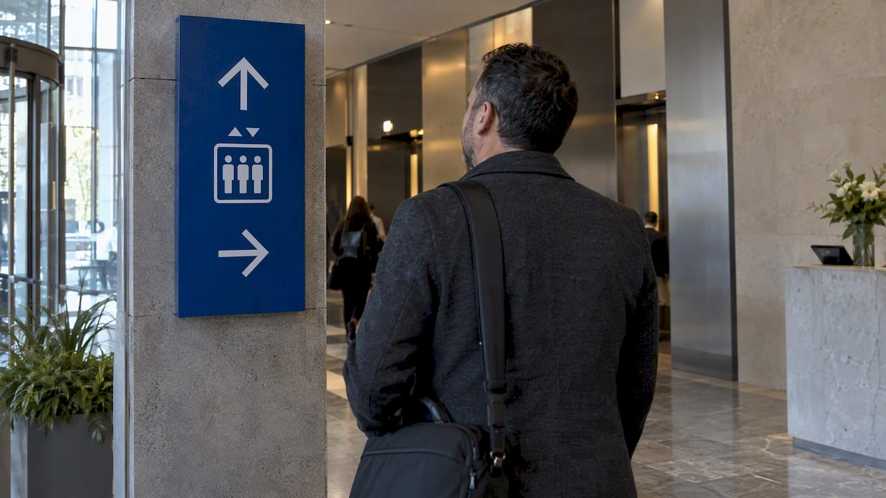 Visitor following directional signage in office lobby
